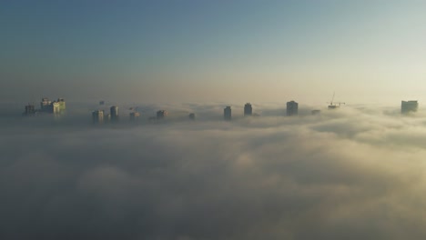 Vista-De-Drones-De-La-Niebla-Sobre-Sharjah,-Horizonte-De-Sharjah-Cubierto-Por-La-Niebla-De-La-Mañana-De-Invierno,-Emiratos-árabes-Unidos,-Imágenes-De-Drones-De-4k