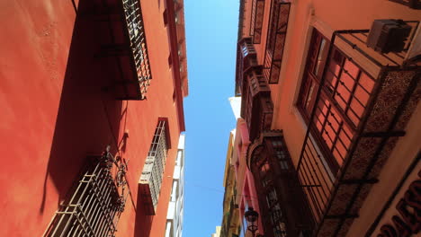 Vista-De-Calles-Estrechas-Con-Edificios-Vibrantes-En-El-Centro-De-La-Ciudad-De-Málaga-Bajo-Un-Cielo-Azul-Claro