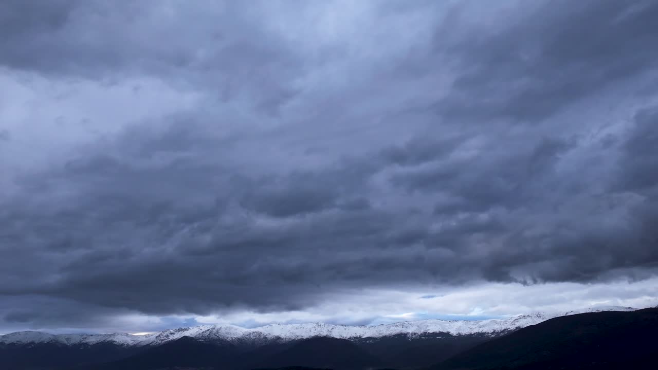 vuelo en gredos en el valle de tietar con un dron visualizando las montañas con sus picos nevados y por encima de ellos una gran cantidad de nubes de tormenta corriendo en un hiperlapso en ávila, españa