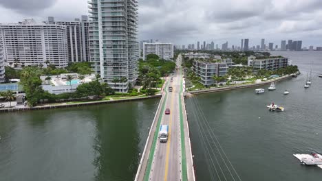 Aerial-flyover-bridge-with-driving-cars-on-Venetian-Islands-with-Miami-skyline-in-background