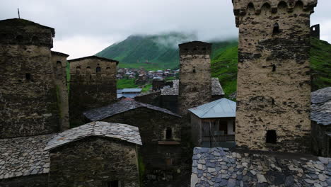 the old alpine village ushguli on a rainy day, caucasus mountains, svaneti region, georgia - aerial pullback