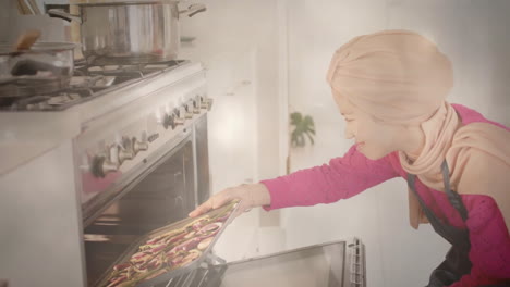 Biracial-woman-in-hijab-putting-tray-of-chopped-vegetables-in-kitchen,-cooking-over-spots-of-light