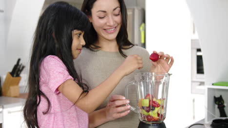 Happy-mother-and-daughter-making-smoothies