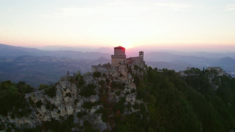 three towers of san marino, italy, drone pull out view during sunset