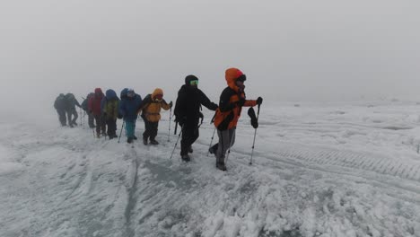 hikers on a snowy glacier in foggy weather