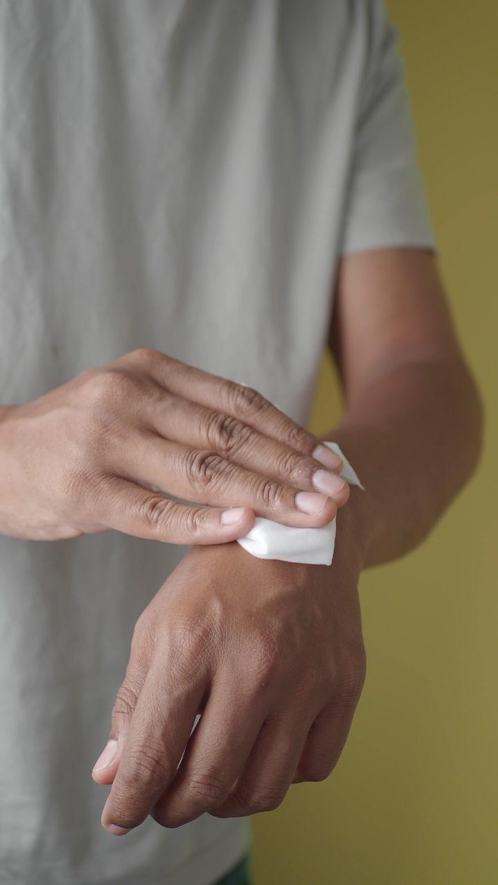 Close-up of a Person Wiping Their Hand with a Wet Wipe