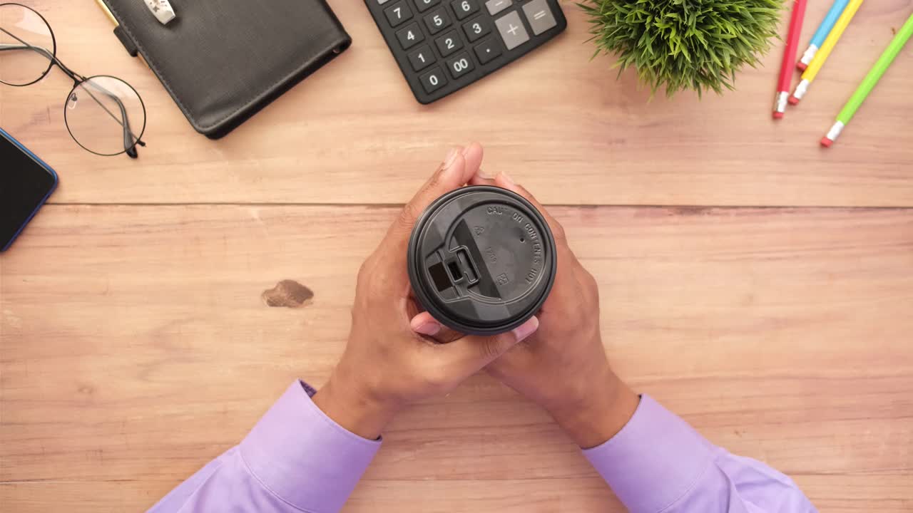 Person holding coffee cup at a desk