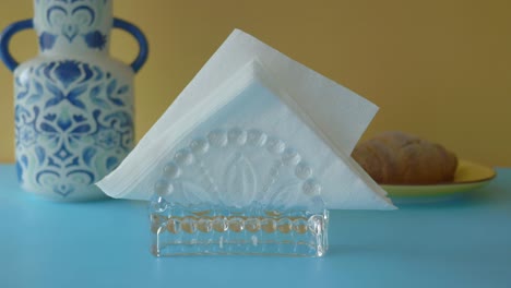 el soporte de servilleta de vidrio en una mesa azul