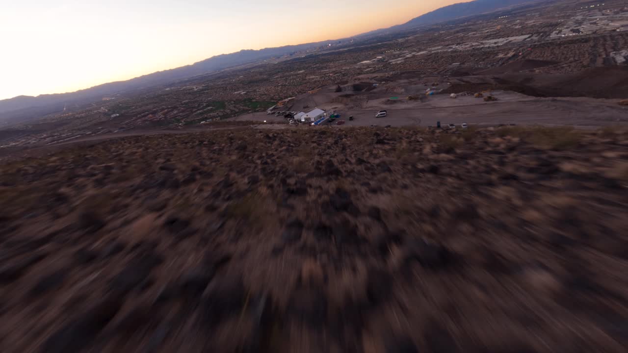 fpv vista aérea del suelo seco y agrietado del desierto acercándose rápidamente a una carpa de eventos