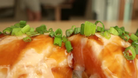 delicious salmon sushi rolls garnished with freshly chopped green chives - macro