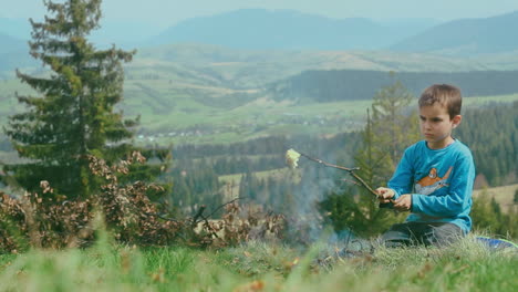 Little-boy-grilling-lard-on-bonfire.-Boy-cooking-food-on-camping-fireplace