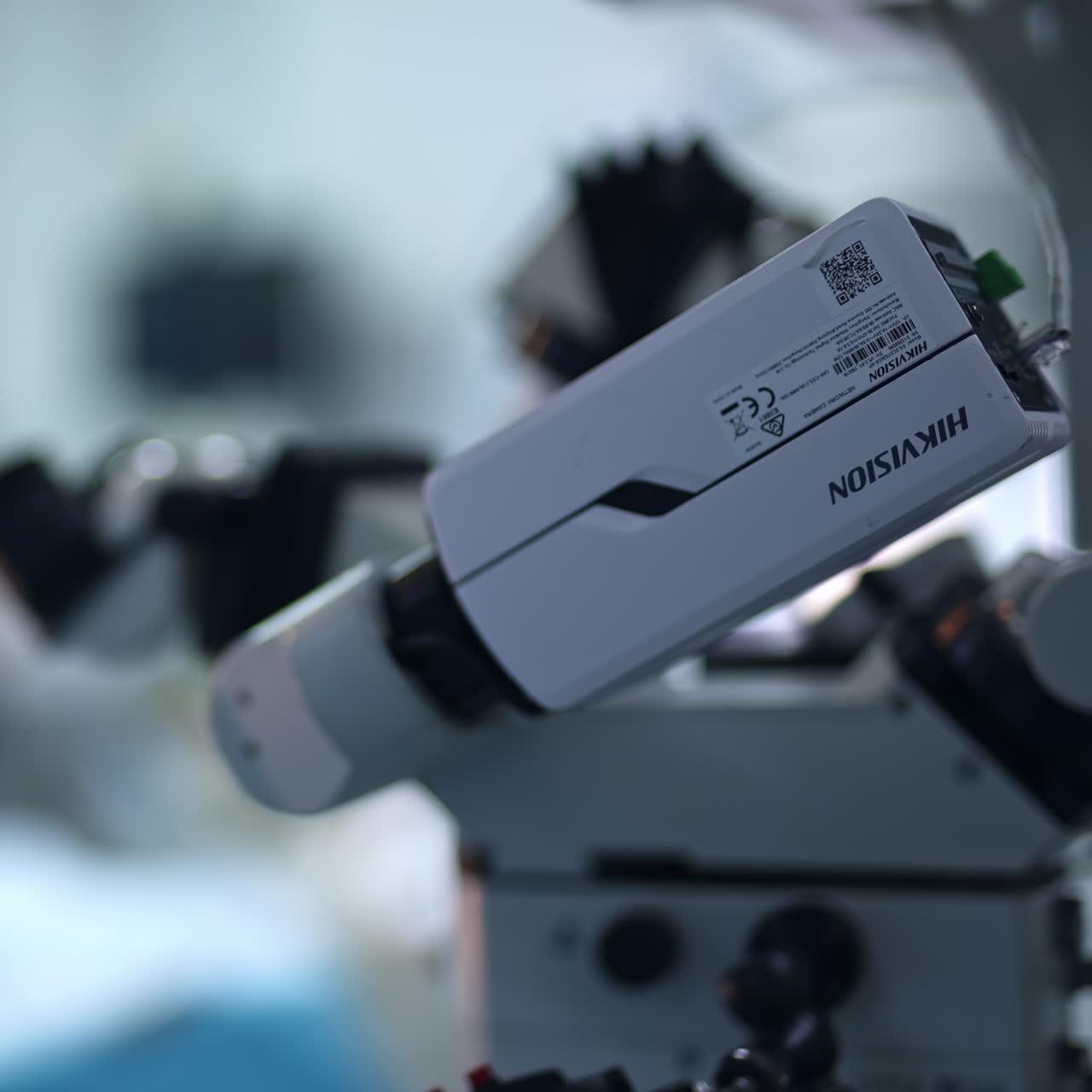 Video surveillance equipment hanging in the modern surgery room. Medics working at backdrop in blur