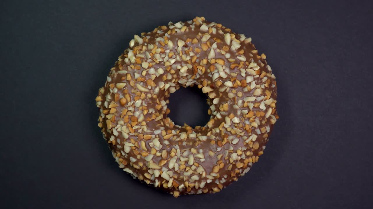 saboroso y fresco rosquilla rosquilla macro disparo de primer plano girando sobre un fondo negro.