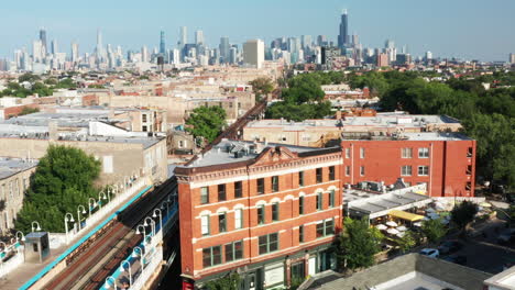 apartment buildings with a crossing railway and a big city skyline - drone shot