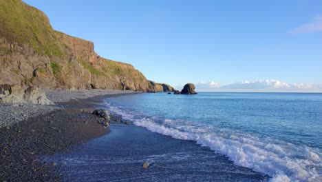 Drone-Volando-A-Lo-Largo-De-Pebble-Beach-Sobre-El-Mar-Bajo-Al-Mar-Pila-Waterford-Irlanda