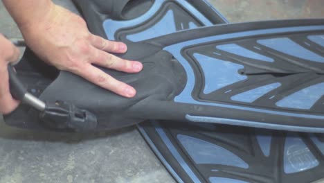 close-up of hands adjusting fin spring straps scuba diving and put it on