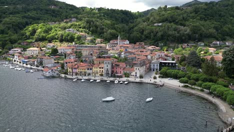 Reverse-rising-aerial-view-of-Pella,-Italy,-a-touristic-town-on-Lake-Orta