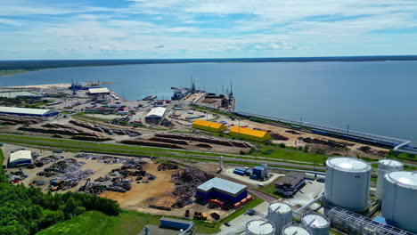 puerto industrial con refinería de petróleo y área de carbón o chatarra, vista aérea