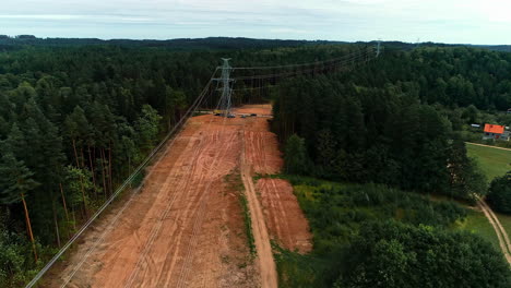 drone following the trajectory of high voltage cables passing in dense forest