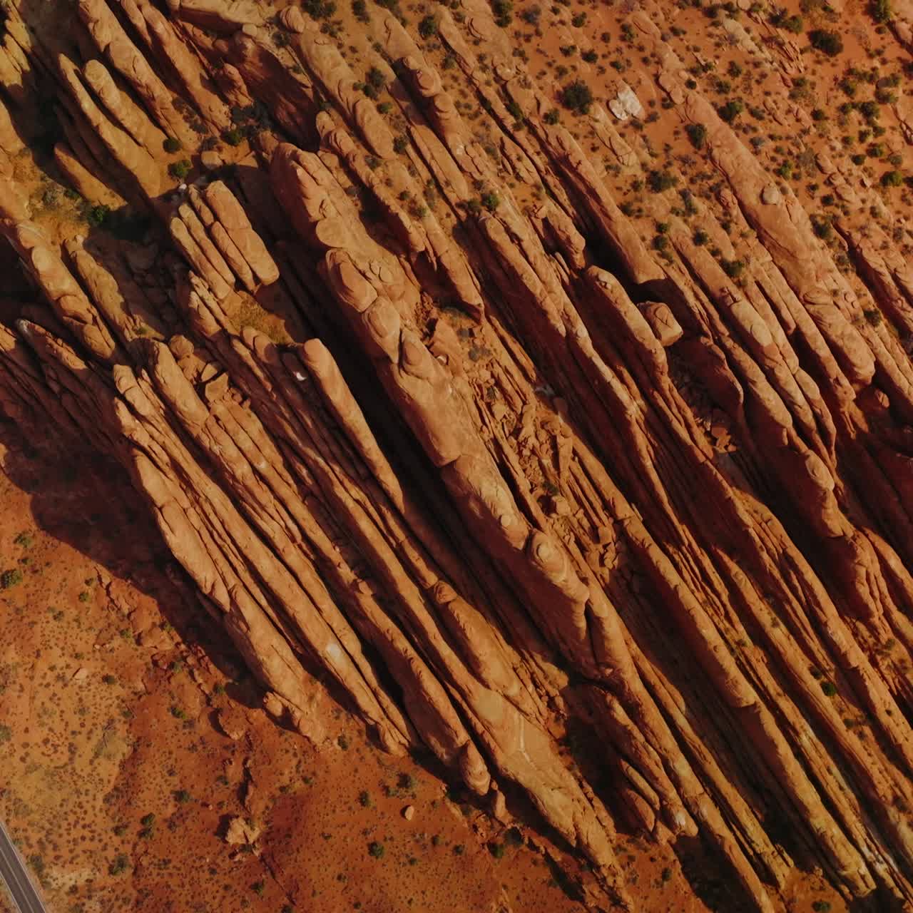 Stunning rocks of American canyons on sunny daytime. Highway road passing through the dry desert in Utah State from top view