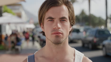 portrait of attractive caucasian man looking serious handsome male tourist in warm sunny urban beachfront background