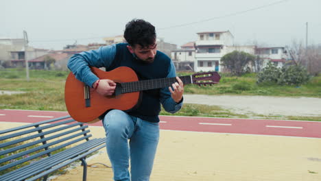 man surrenders to the melody of his guitar playing outdoors