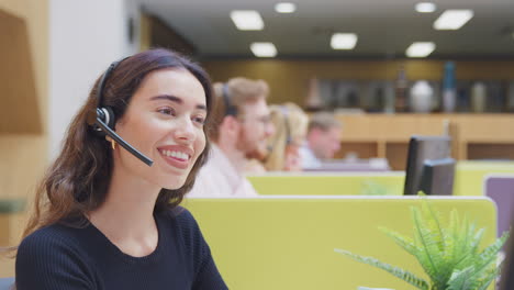 mujer de negocios con auriculares de teléfono hablando con la persona que llama en el centro de servicios al cliente