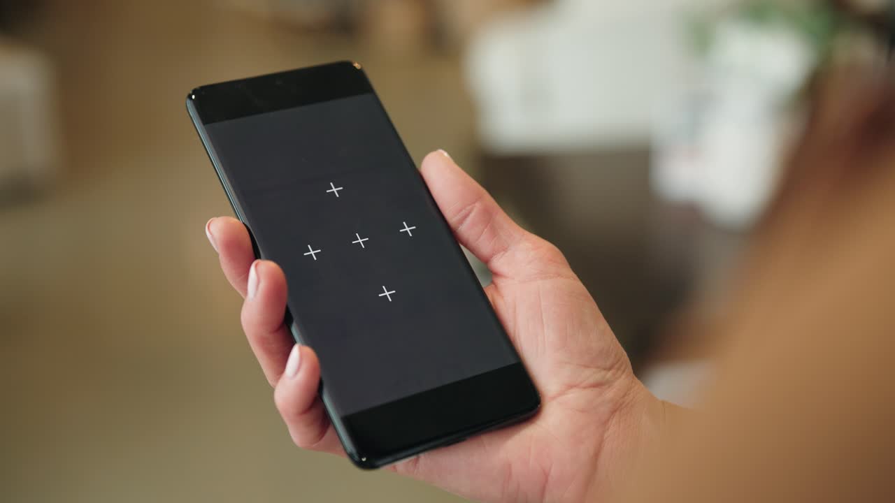 Smartphone with markers held by woman, background out of focus