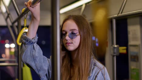 Tired,-bored-young-woman-standing-alone-in-bus-transport-after-hard-work-day-and-falling-asleep