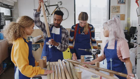 multi-cultural team in workshop assembling hand built sustainable bamboo bicycle frame