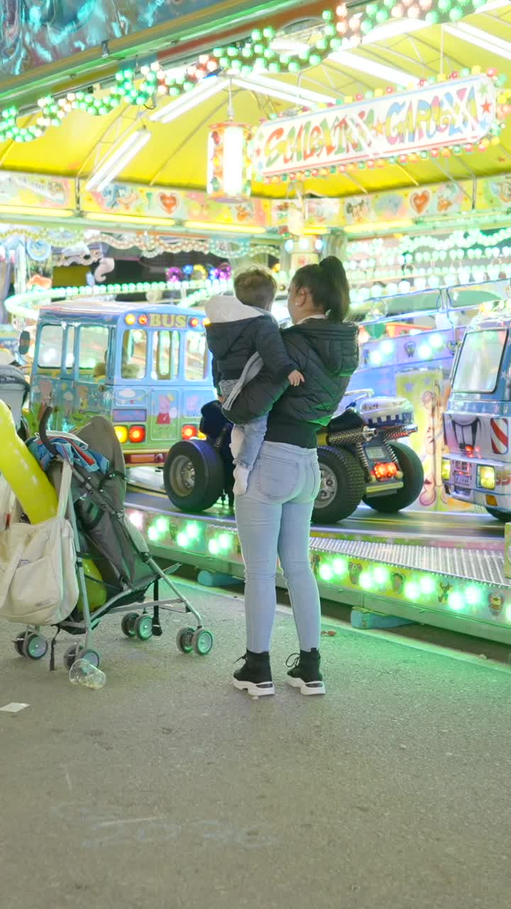 Mother and child at a brightly lit carnival
