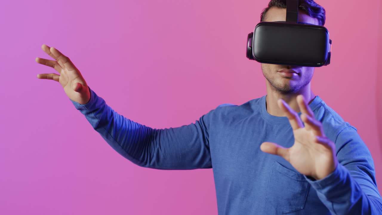 video di un uomo biraciale che usa le cuffie vr su sfondo rosa e viola