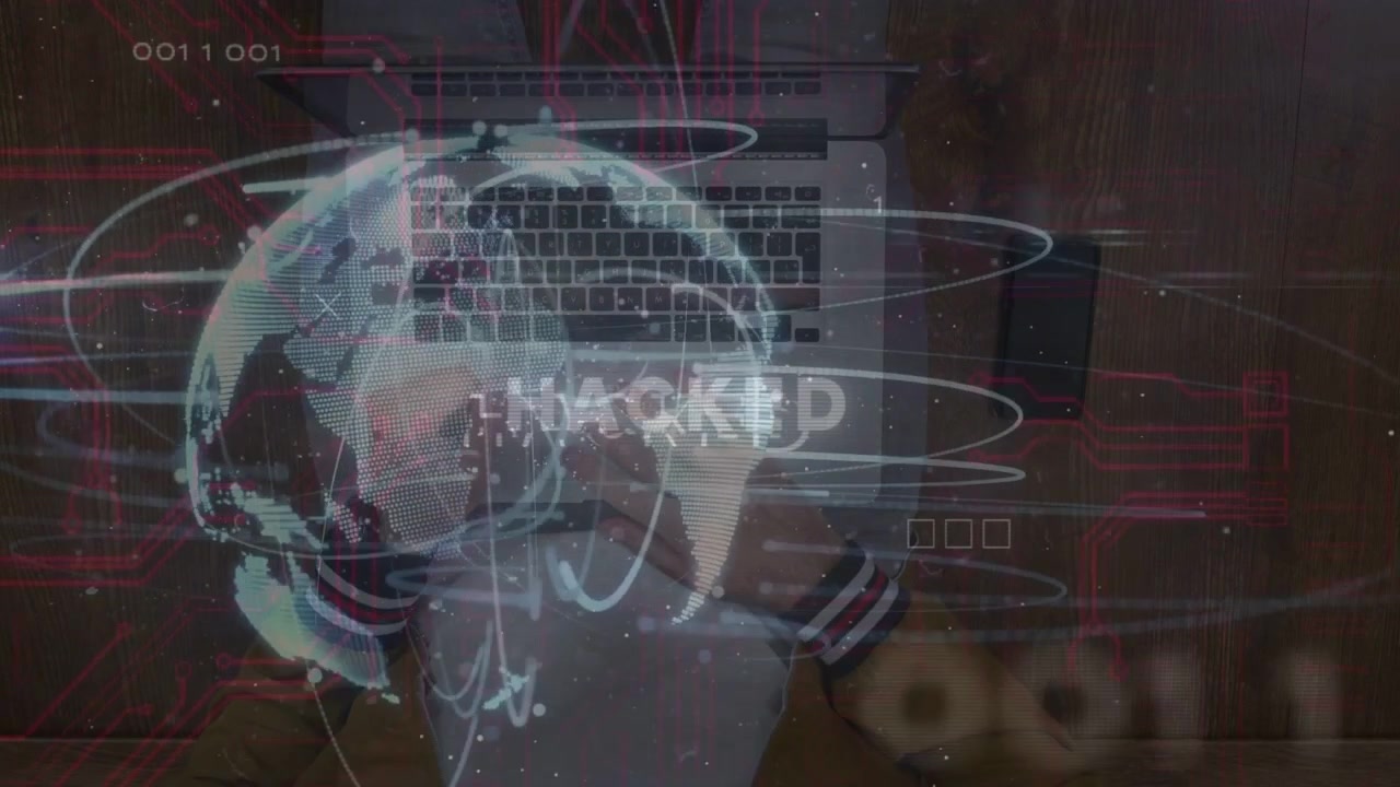 Man typing laptop at desk, globe appearing and causing HACKED warning pulsing across phone tech HUD
