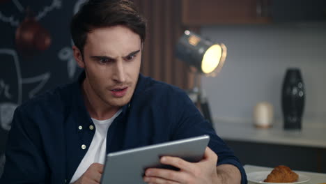 focused businessman getting good news on tablet computer at remote workplace.