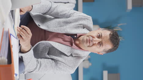 vertical video of home office worker old man confused and thoughtful.
