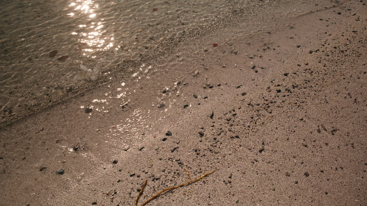 The water flows slowly into the beach on a sunny day in Norway