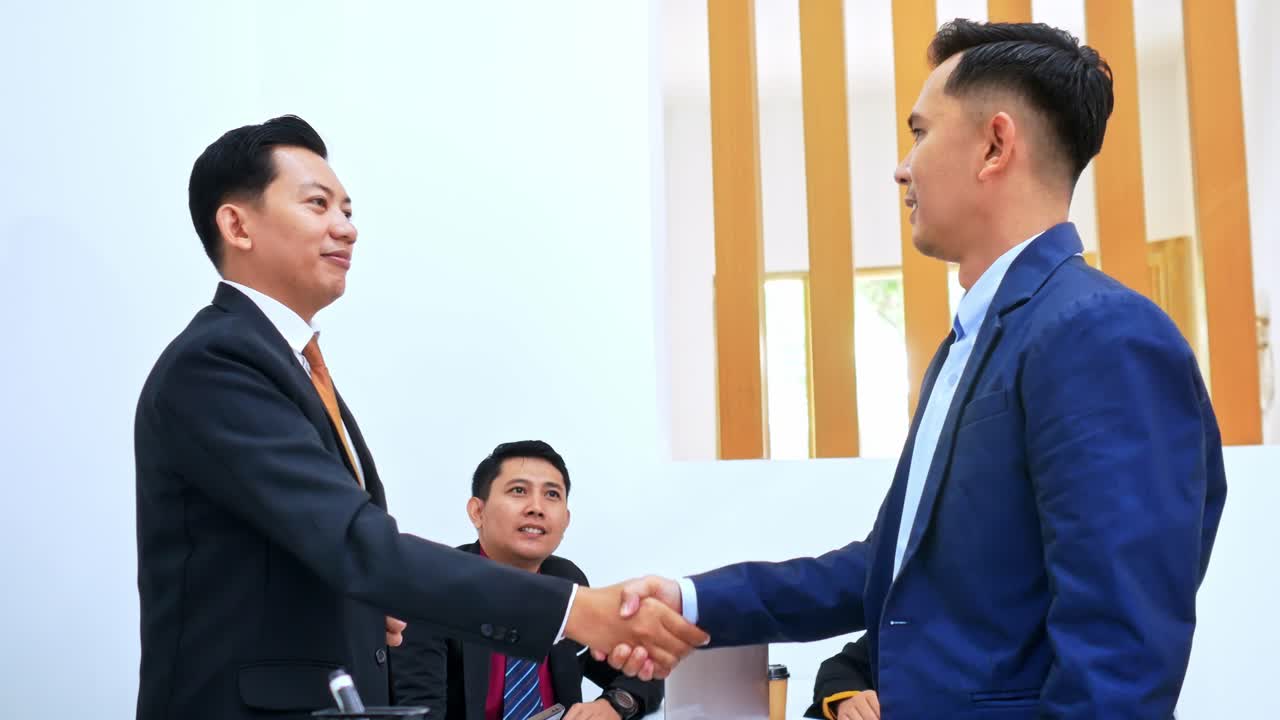 Confident business professionals sealing deal with handshake in modern office setting