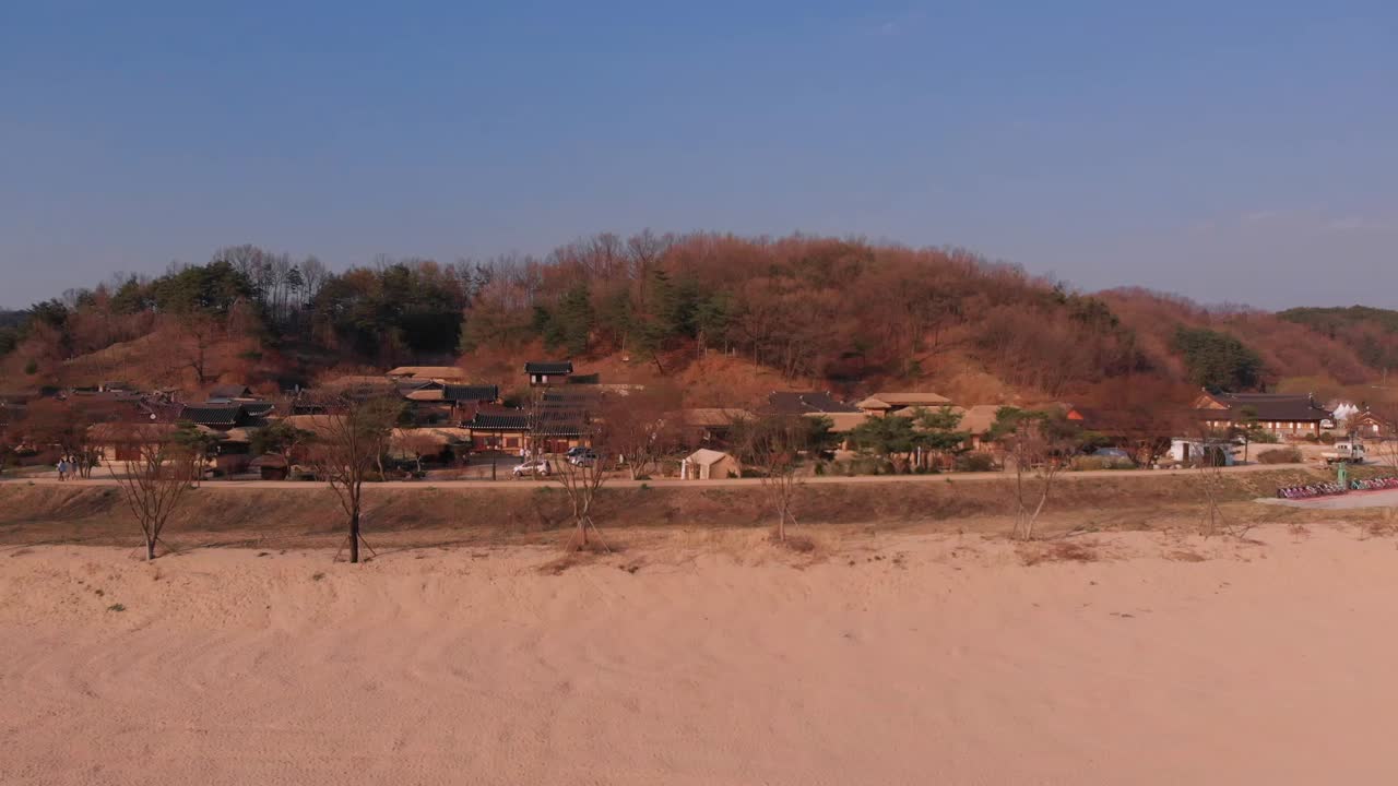 Aerial gentle tilt down rise up in front of Korean traditional village