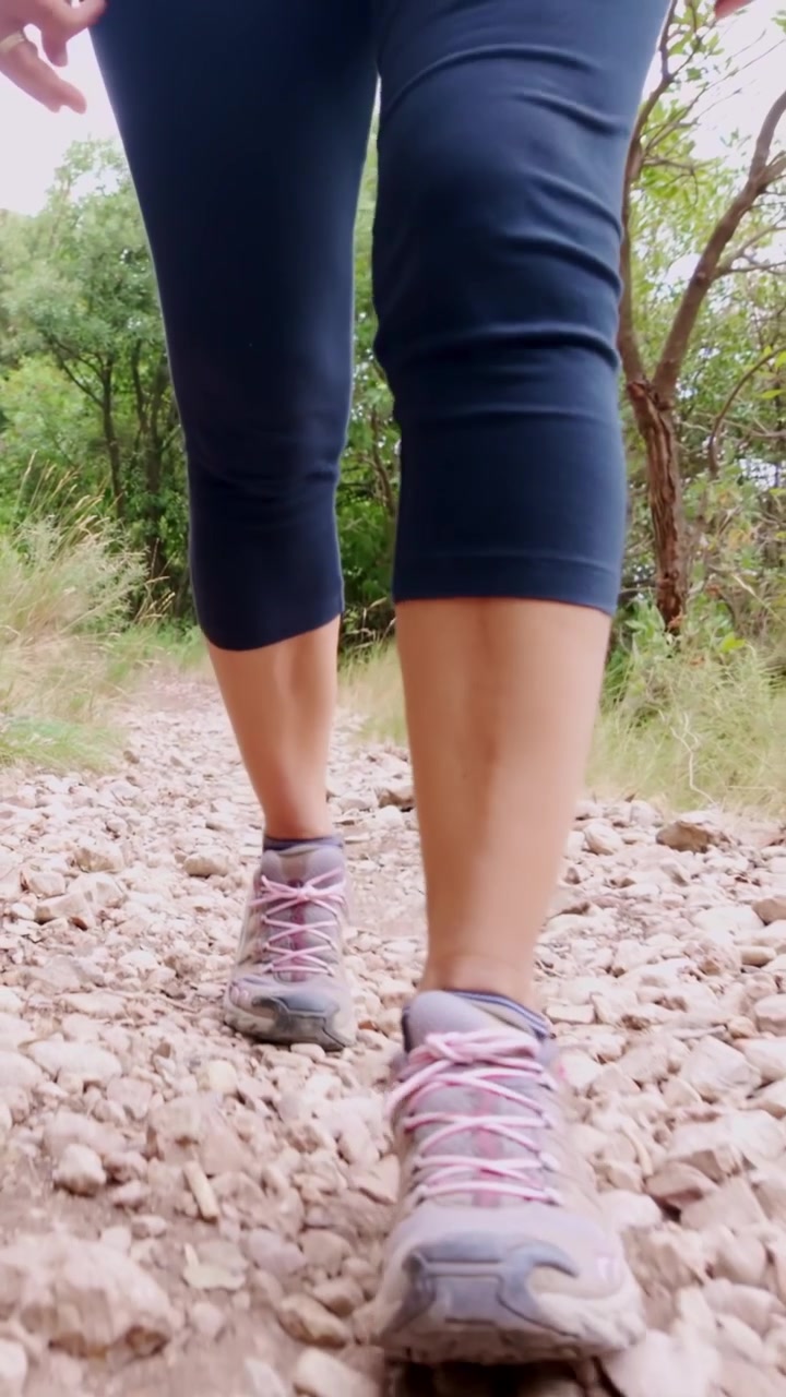 Mulher fazendo trilha em caminho de montanha rochoso em Montserrat