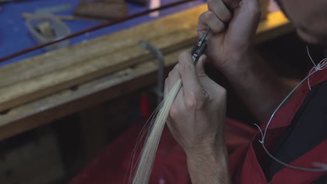 maestro artesano anónimo trabajando en el arco del violín