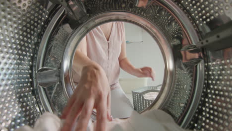 Woman-puts-white-linen-inside-washing-machine