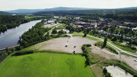 Ländliche-Stadthäuser-In-Der-Nähe-Des-Flusses-Mit-Grünem-Grasland-Im-Sommer