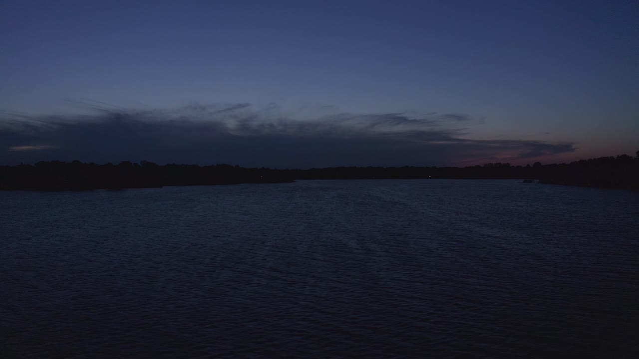 Movimento aereo basso con dolly attraverso il lago al crepuscolo.