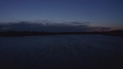 low rising aerial dolly shot across lake at twilight