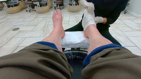 pov, female pedicurist using hot tower on man's feet at the end of a pedicure