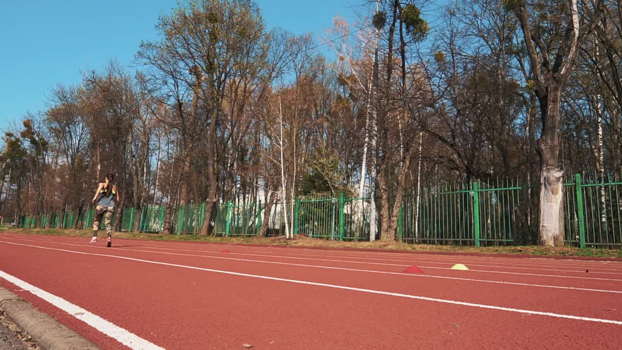 Summer outdoors training. Athletic woman running on track. Beautiful body.