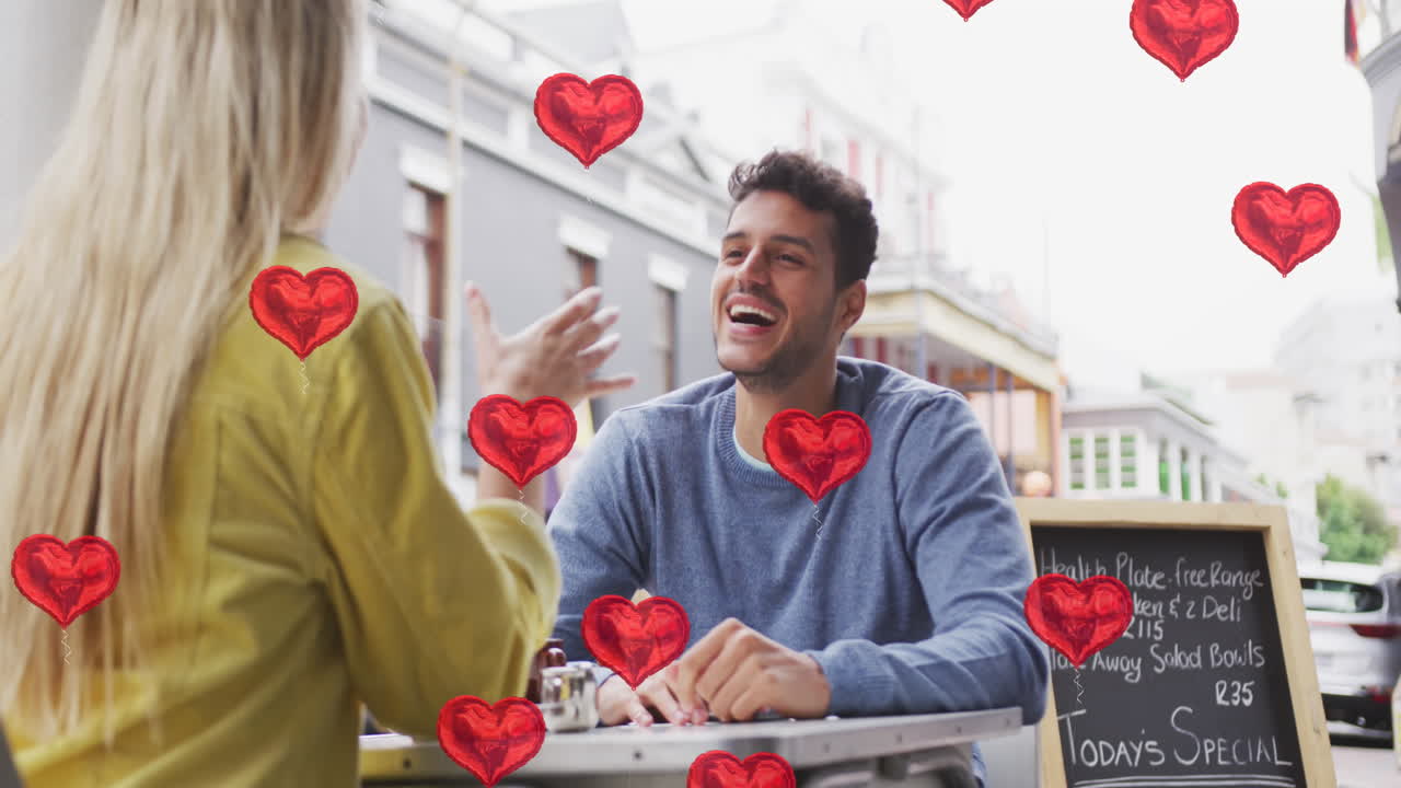 animación de iconos de corazón flotando sobre una feliz pareja caucásica hablando y sonriendo