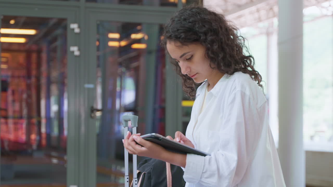 mujer usando tableta en la estación de tren