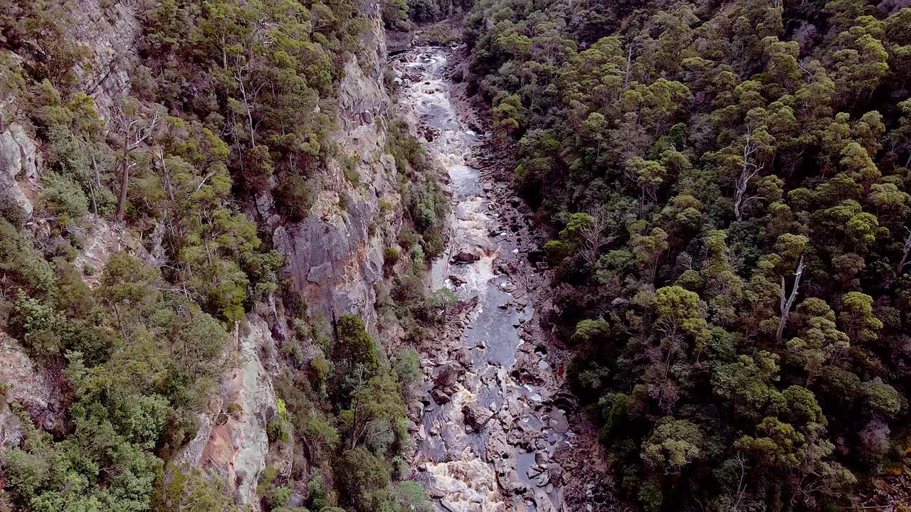 fotografía aérea de arriba hacia abajo sobre el río estrecho que fluye a través del cañón de levin, tasmania, australia durante el día