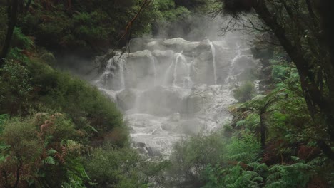 Breathtaking-slow-motion-of-raw-power-of-waterfall-in-New-Zealand-forest-Rotorua,-steamy-geothermal